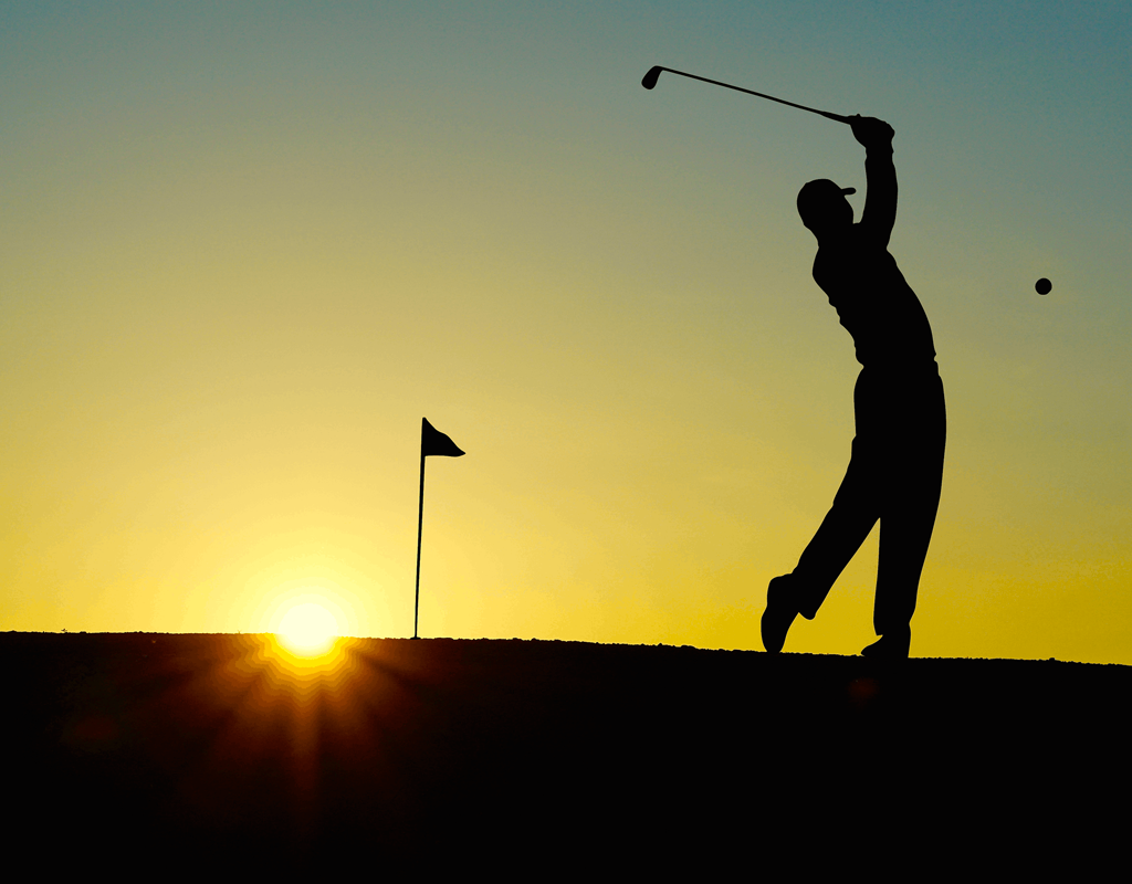 Golfer swinging in the sunset